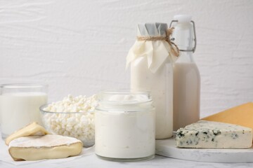 Different fresh dairy products on white marble table