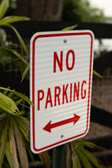 No Parking sign with arrow isolated in greenery