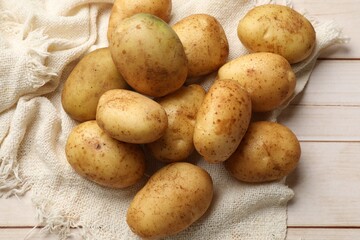 Raw fresh potatoes on light wooden table, top view