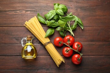 Raw pasta, spices and products on wooden table, flat lay