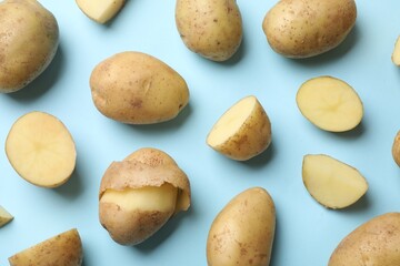 Fresh raw potatoes on light blue background, flat lay