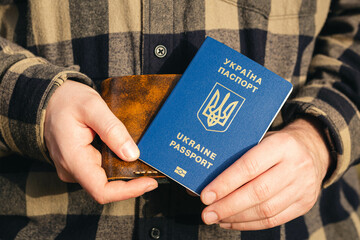 Biometric passport in the hands of a Ukrainian and a wallet, close-up.