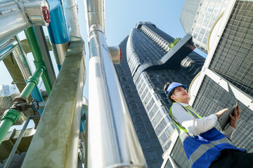 Industrial engineer adjusting pipeline valve with radio communication on construction site....