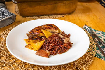 Baked chicken leg with red rice, pineapple pice and bacon