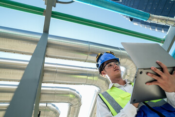 Industrial engineer adjusting pipeline valve with radio communication on construction site....