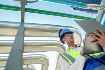 Industrial engineer adjusting pipeline valve with radio communication on construction site....