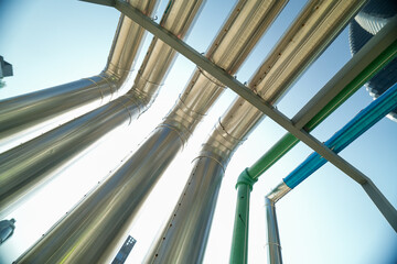 Industrial pipes and structures under clear blue sky, showcasing infrastructure on a construction...