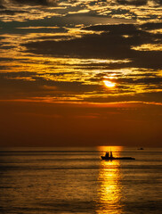 Silhouette boat on beautiful sunset sky background vertical format
