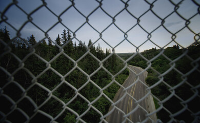 View Of Road Through Chain Link Fencing