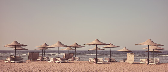 Retro toned photo of a beach with sun loungers and umbrellas, Egypt.