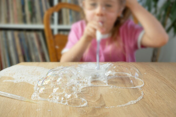 Little girl blows bubbles made of soap foam, bursts, kids fun games, diy soap bubbles, making...