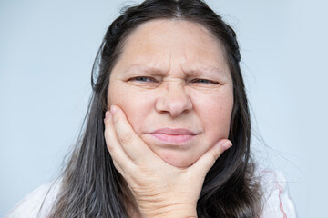 caucasian mature woman face with gumboil, toothache, gum inflammation, painful Discomfort Health,...