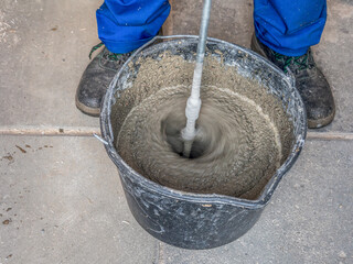 Construction worker mixing mortar in a bucket