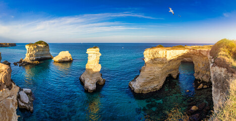Stunning seascape with cliffs rocky arch and stacks (Faraglioni) at Torre Sant Andrea, Salento...