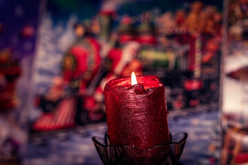 Red candle on a colorful Christmas background, seasonal bg