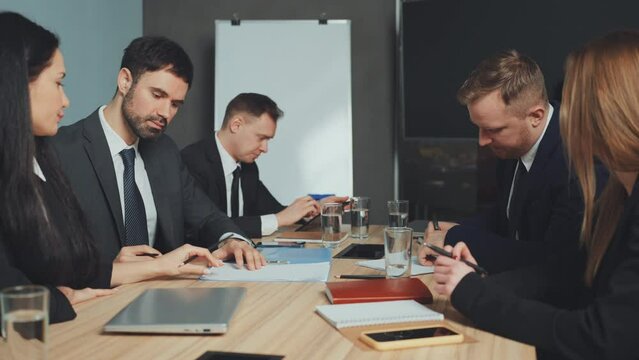 Colleagues finalize agreement with handshake and document signing during business meeting, successful negotiation and partnership