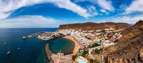 Puerto de Mogan with the beach in Gran Canaria, Spain. Favorite vacation place for tourists and locals on island. Harbor in Puerto de Mogan and Playa Mogan on Grand Canary Island, Spain.