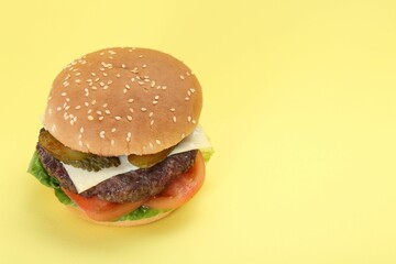 Burger with delicious patty on yellow background. Space for text