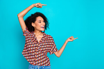 Photo of excited lovely lady dressed print shirt pointing fingers looking empty space isolated teal...