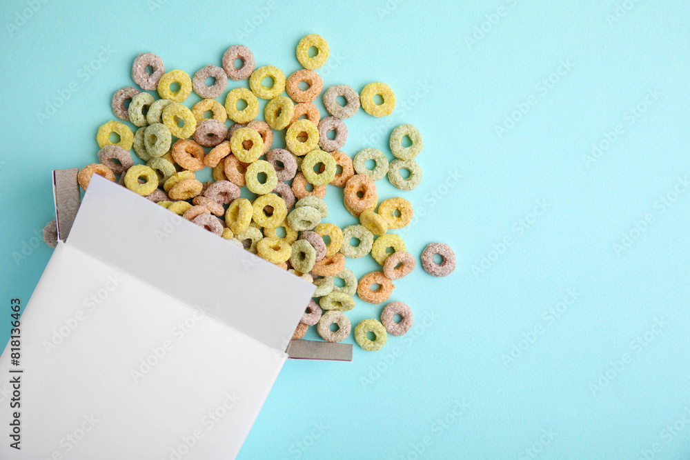 Canvas Prints Paper box with tasty cereal rings on light blue background, flat lay. Space for text