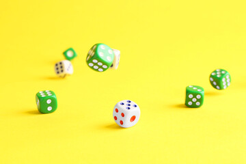 Many color game dices falling on yellow background