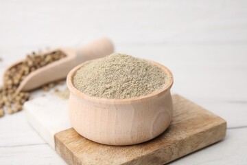 Aromatic spice. Ground pepper in bowl on white wooden table, closeup
