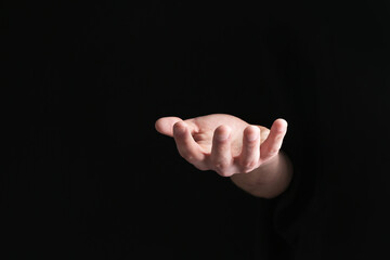 Man holding something in his hand on black background, closeup
