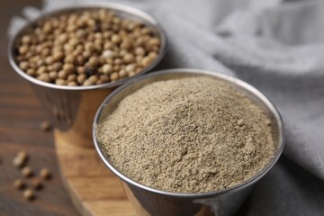 Ground pepper and peppercorns on wooden table, closeup