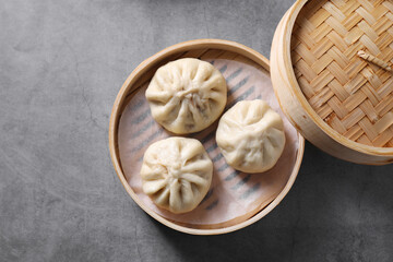 Delicious bao buns (baozi) on grey textured table, top view