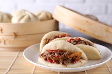 Plate with delicious gua bao (pork belly buns) on table, closeup