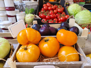 A display of goods, various fresh vegetable yellow and red tomatoes, cabbage harvested for sale at a grocery. spot focus