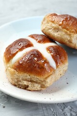 Tasty hot cross buns on gray textured table, closeup