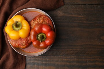 Delicious stuffed bell peppers on wooden table, top view. Space for text