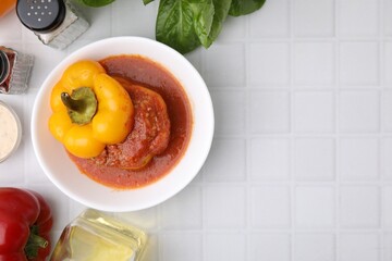 Delicious stuffed bell pepper served on white tiled table, flat lay. Space for text
