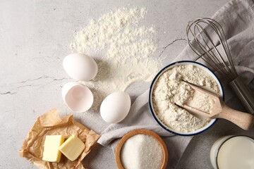 Different ingredients for dough and whisk on light textured table, flat lay