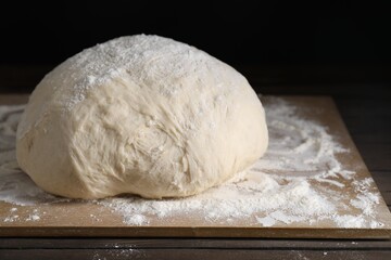 Raw homemade dough on wooden table, closeup