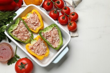 Raw stuffed peppers and ingredients on white table, flat lay. Space for text