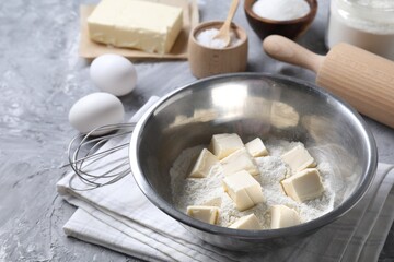 Making shortcrust pastry. Different ingredients for dough, whisk and rolling pin on grey table