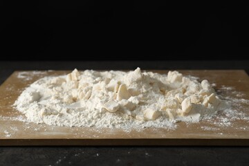 Making shortcrust pastry. Flour, butter and board on grey table