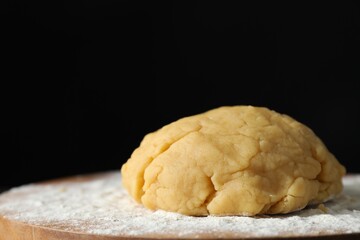 Making shortcrust pastry. Raw dough and flour on board, closeup. Space for text