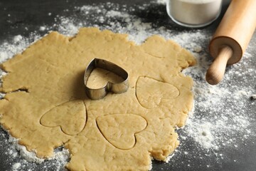 Making shortcrust pastry. Raw dough, flour, cookie cutter and rolling pin on grey table