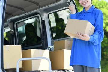 ガッツポーズをする配送ドライバーの女性
