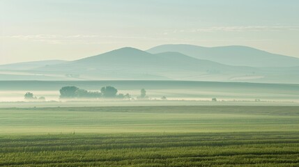 A hazy landscape with the silhouette of a distant mountains shadow emerging from the mist.