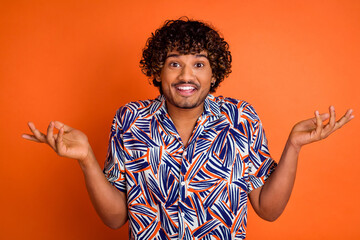 Photo of attractive young man excited confused shrug shoulders dressed stylish colorful clothes isolated on orange color background