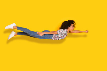 Full body photo of attractive young woman flying superhero dressed stylish leopard print clothes isolated on yellow color background © deagreez