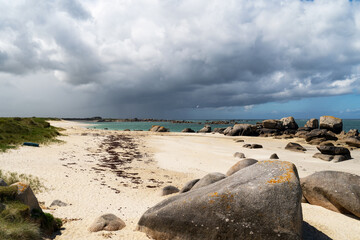 A spring day by the sea, with its turquoise waters under a very cloudy sky in Brittany.