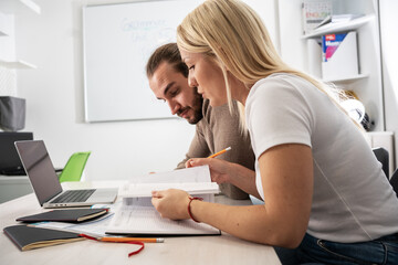 Two language learning students are focused on taking a test in their language class, showcasing...