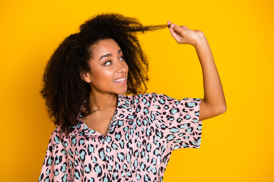 Photo portrait of attractive young woman look hld hair strand dressed stylish leopard print clothes isolated on yellow color background