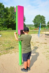 A child playing with a periscope in the playground