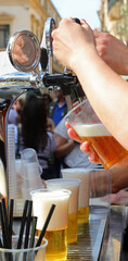 Bartender pouring a glass of ice-cold lager during an outdoor party